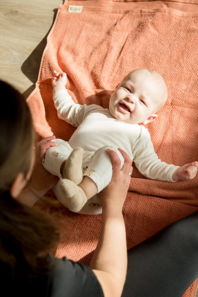 Baby op een oranje deken tijdens Mama & Baby Yoga