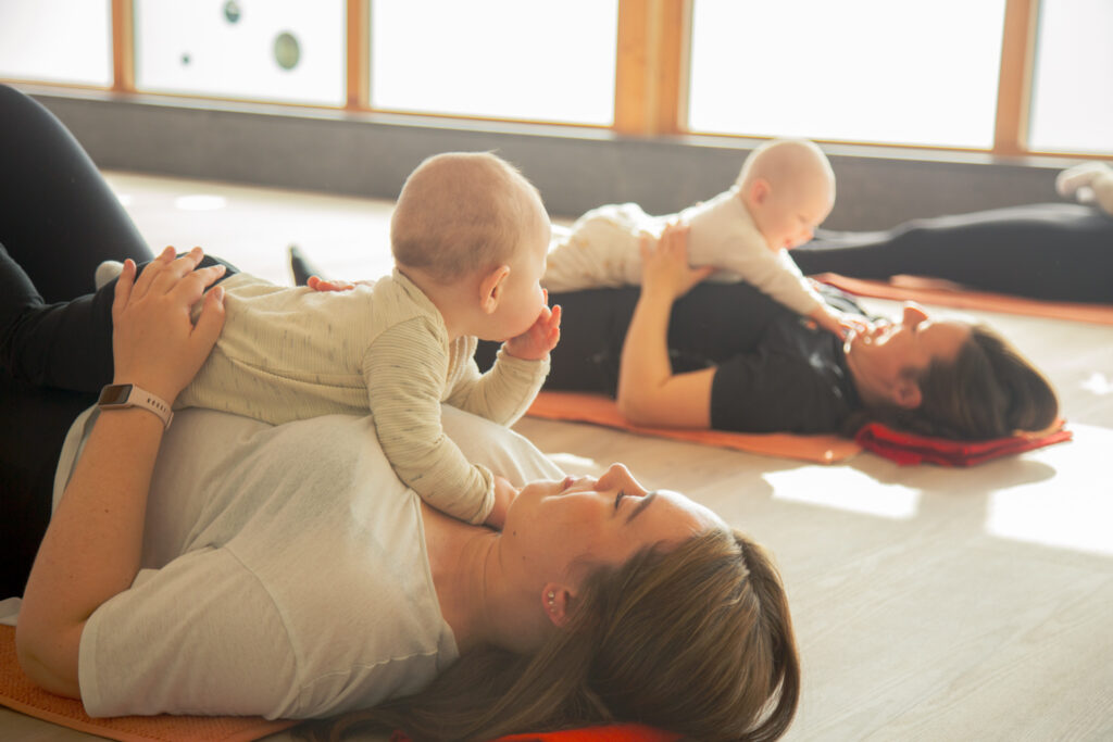 Moeder en baby liggen samen op de mat tijdens Mama & Baby Yoga