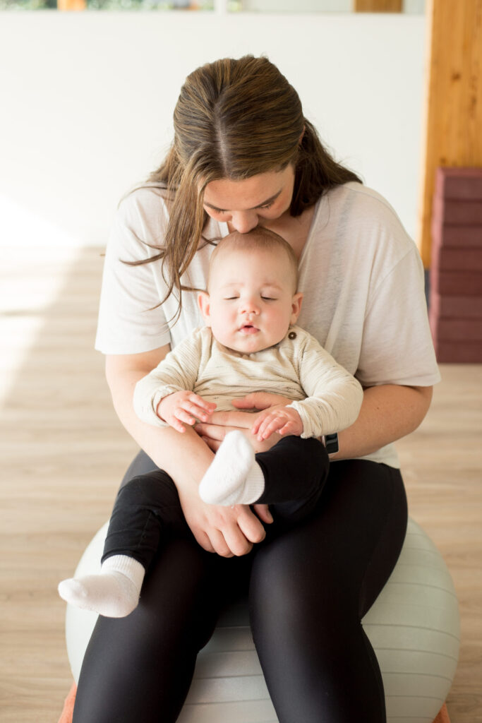 Moeder met haar baby op schoot tijdens Mama & Baby Yoga bij Ires